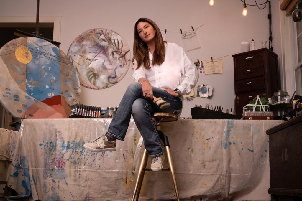 Nancy Joyce on stool with paintbrush